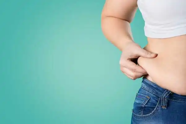 Image of woman pinching her love handles to show weight gain Hereford
